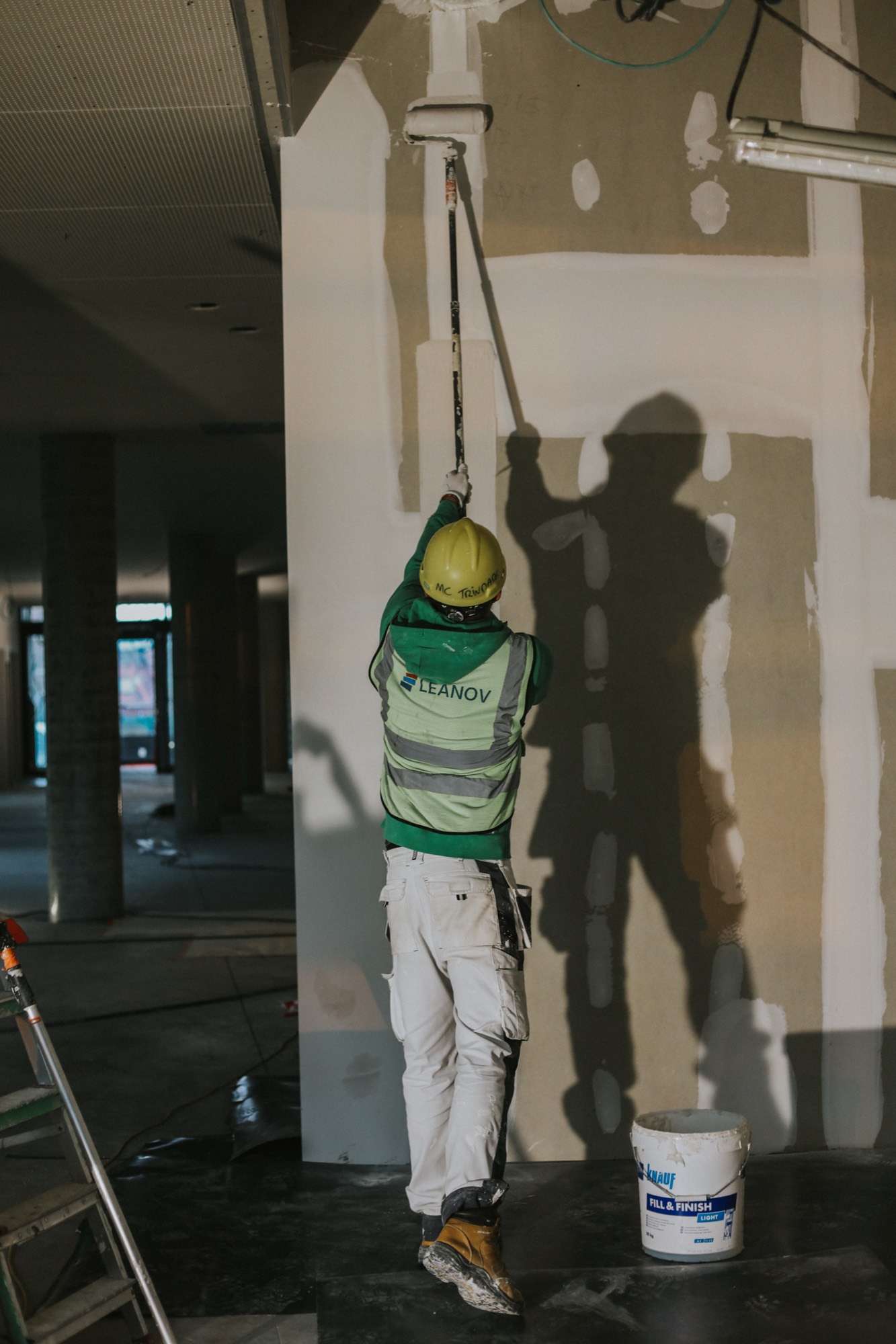 Operário LEANOV a aplicar acabamento numa parede em obra