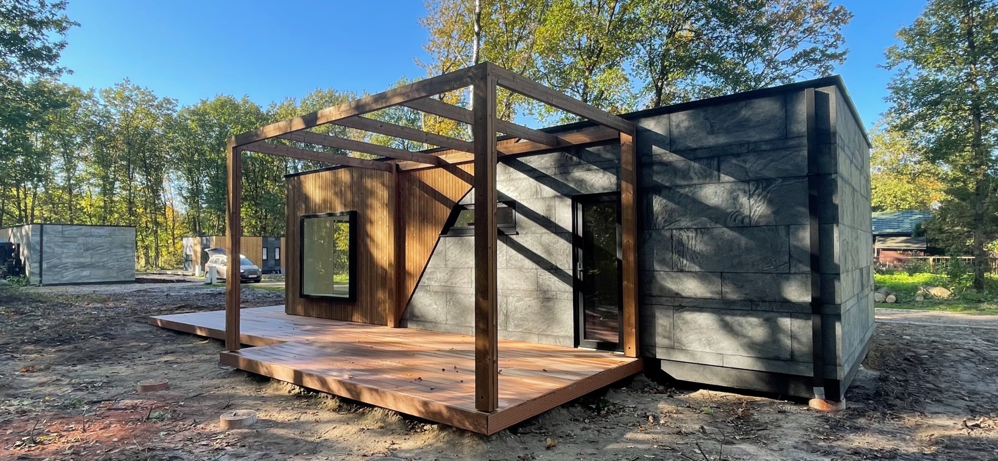 Moradia modular LEANOV com fachada envidraçada e ripado de madeira